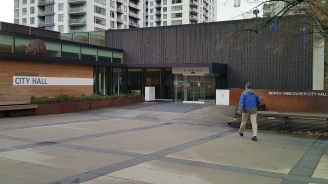 man waling past city hall.