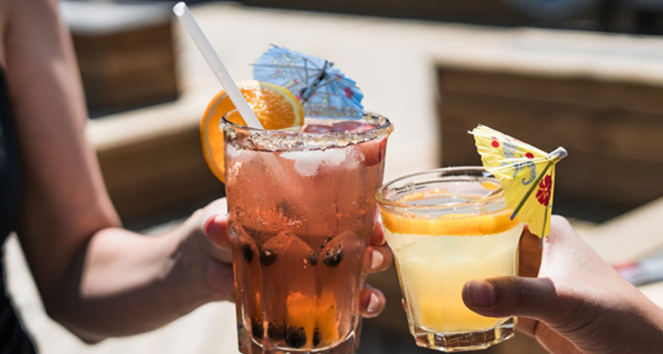 Two drinks in hand.